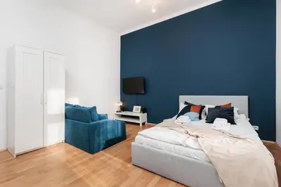 a bedroom with a bed and a blue wall at Stylowy apartament - 6 sypialni - Kraków, Stare Miasto - by Upstairs in Kraków