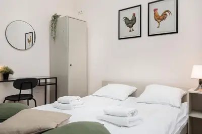 a white bedroom with a bed with towels on it at Stylowy apartament - 6 sypialni - Kraków, Stare Miasto - by Upstairs in Kraków