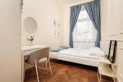 a small bedroom with a bed and a desk and a window at Stylowy apartament - 6 sypialni - Kraków, Stare Miasto - by Upstairs in Kraków