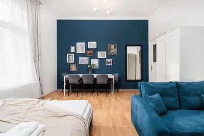 a living room with a blue wall and a blue couch at Stylowy apartament - 6 sypialni - Kraków, Stare Miasto - by Upstairs in Kraków