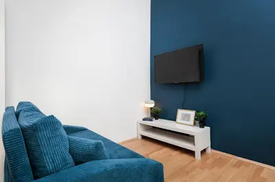 a living room with a blue couch and a tv at Stylowy apartament - 6 sypialni - Kraków, Stare Miasto - by Upstairs in Kraków