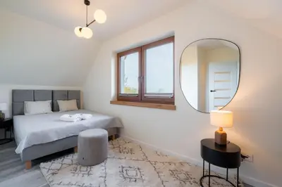 a bedroom with a bed and a mirror at Domki Kamieniec in Marcyporęba