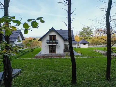 a white house with a black roof at Domki Kamieniec in Marcyporęba