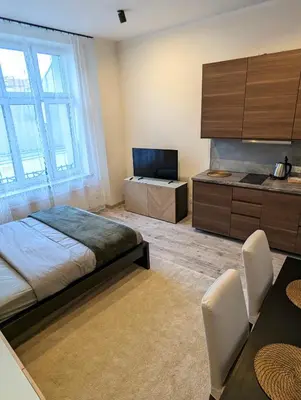 a bedroom with a bed and a tv and a table at Apartment A3 in downtown of Krakow in Kraków