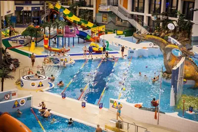 an indoor water park with people in a pool at Apartment A3 in downtown of Krakow in Kraków