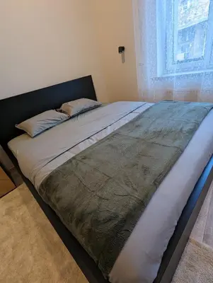 a large bed in a bedroom with a window at Apartment A3 in downtown of Krakow in Kraków