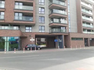 a car parked in front of a brick building at Apollo Apartments Zabłocie 21 in Kraków