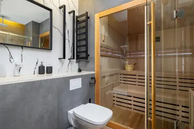 a bathroom with a toilet and a glass shower at Apartment with Private Sauna - Dietla 21 street in Kraków