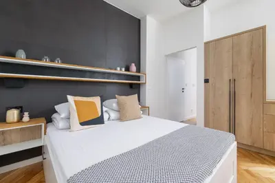 a bedroom with a white bed and a black wall at Apartment with Private Sauna - Dietla 21 street in Kraków