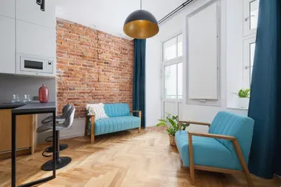 a living room with a brick wall and a blue couch at Apartment with Private Sauna - Dietla 21 street in Kraków