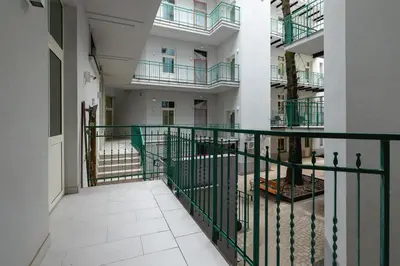 an empty hallway of an apartment building with a green railing at Apartment with Private Sauna - Dietla 21 street in Kraków