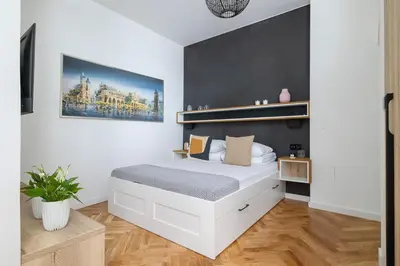 a bedroom with a white bed and a black wall at Apartment with Private Sauna - Dietla 21 street in Kraków