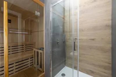 a shower with a glass door in a bathroom at Apartment with Private Sauna - Dietla 21 street in Kraków