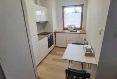 a small white kitchen with a table and chairs at Novum apartment in the city center in Kraków