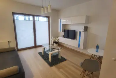 a living room with a coffee table and a kitchen at Novum apartment in the city center in Kraków