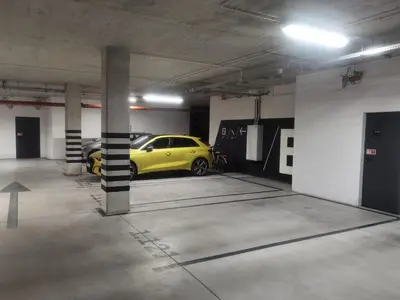 a parking garage with a yellow car parked in it at Novum apartment in the city center in Kraków