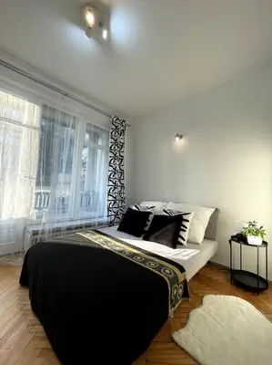 a bedroom with a bed with black and white pillows at Cracow Heart Apartment in Kraków