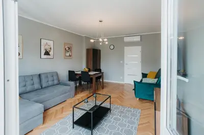 a living room with a blue couch and a table at Connecta Apartament in City Center with AC in Kraków