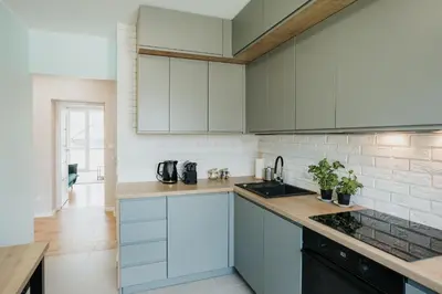 a kitchen with white cabinets and a sink at Connecta Apartament in City Center with AC in Kraków