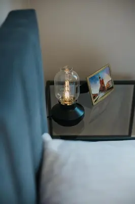 a glass table with a candle on top of a bed at Connecta Apartament in City Center with AC in Kraków