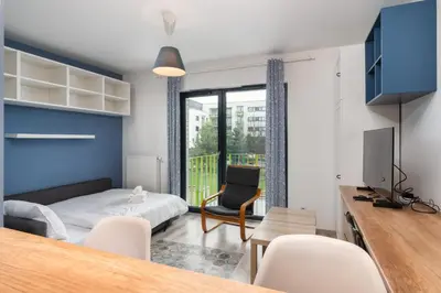 a bedroom with a bed and a desk with a tv at Bronowice Standard Studio by BookingHost in Kraków