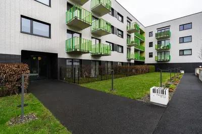 a building with green balconies on the side of it at Bronowice Standard Studio by BookingHost in Kraków
