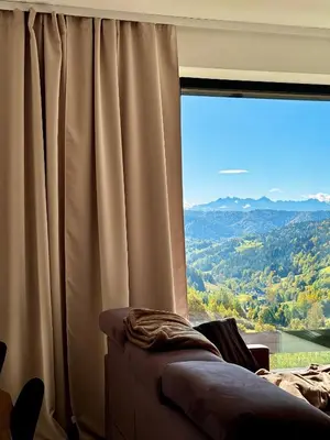 a living room with a large window with a view at Bacówki Resort in Ochotnica Górna