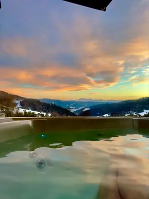 a hot tub with a view of the mountains at Bacówki Resort in Ochotnica Górna