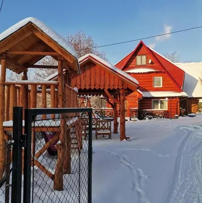 a wooden house with a fence in the snow at Dom na Smyrakach in Zawoja