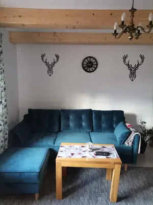 a living room with a blue couch and a coffee table at Dom na Smyrakach in Zawoja