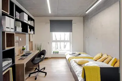 a bedroom with a bed and a desk and a computer at SHED Living Kraków in Kraków