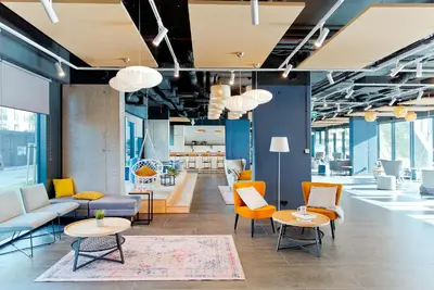 a lobby with couches and chairs and tables at SHED Living Kraków in Kraków