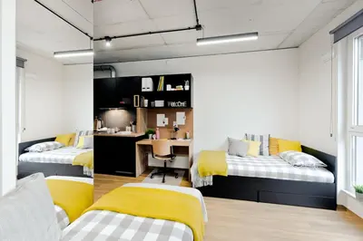 a bedroom with two beds and a desk in it at SHED Living Kraków in Kraków