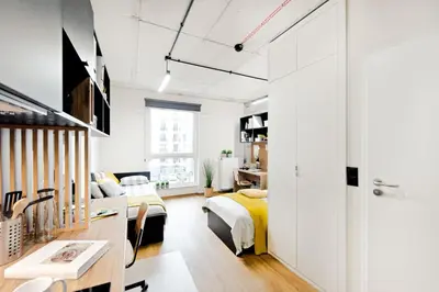 a bedroom with a bed and a desk in a room at SHED Living Kraków in Kraków