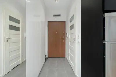 a hallway with white walls and a brown door at Cosy Ariańska Apartment for 2 in Cracow Center by Noclegi Renters in Kraków