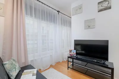 a living room with a tv and a large window at Cosy Ariańska Apartment for 2 in Cracow Center by Noclegi Renters in Kraków