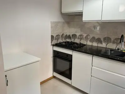 a kitchen with white cabinets and a stove top oven at OMORIKA na Zamkowej in Kraków