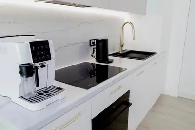 a kitchen counter with a coffee maker and a sink at APARTAMENT WRAŻEŃ Kraków in Kraków