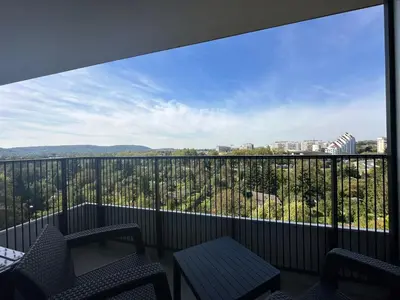 a balcony with chairs and a view of the city at APARTAMENT WRAŻEŃ Kraków in Kraków