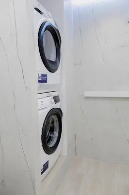 a washer and dryer in a corner of a bathroom at APARTAMENT WRAŻEŃ Kraków in Kraków