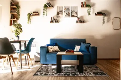 a living room with a blue couch and a table at Na Kamieńcu domki in Rzyki