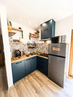 a kitchen with blue cabinets and a refrigerator at Na Kamieńcu domki in Rzyki