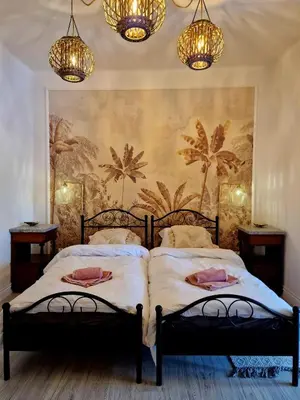 a bedroom with two beds with chandeliers at Apartament Kety Rynek Mickiewicza in Kęty