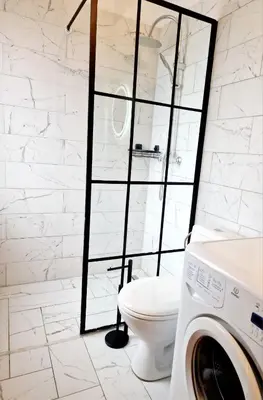 a white bathroom with a toilet and a glass shower at Apartament Kety Rynek Mickiewicza in Kęty