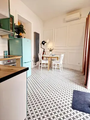 a kitchen with a refrigerator and a table with chairs at Apartament Kety Rynek Mickiewicza in Kęty