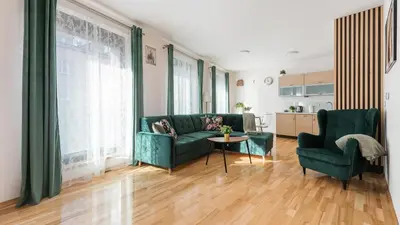 a living room with a green couch and two chairs at Angel City, Sun & Snow in Kraków