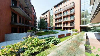 a courtyard of an apartment building with a garden at Angel City, Sun & Snow in Kraków