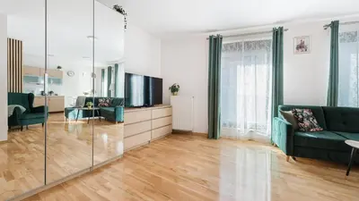 a living room with a couch and a tv at Angel City, Sun & Snow in Kraków