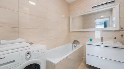 a bathroom with a washing machine and a sink at Angel City, Sun & Snow in Kraków