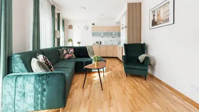 a living room with a green couch and two chairs at Angel City, Sun & Snow in Kraków
